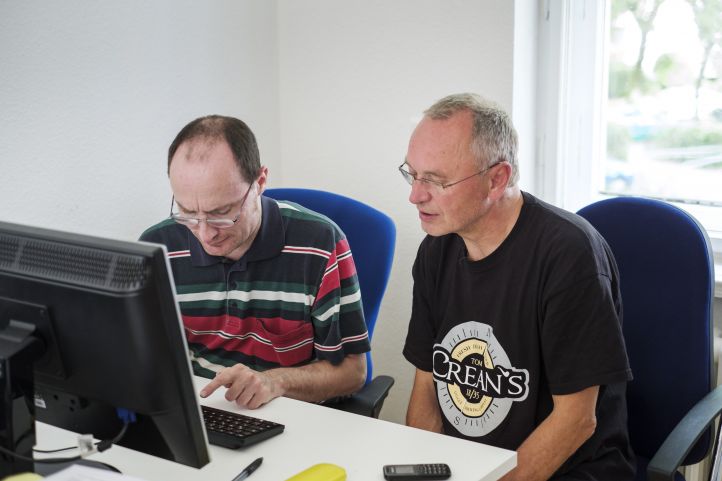 Zwei Männer sitzen an einem Computer