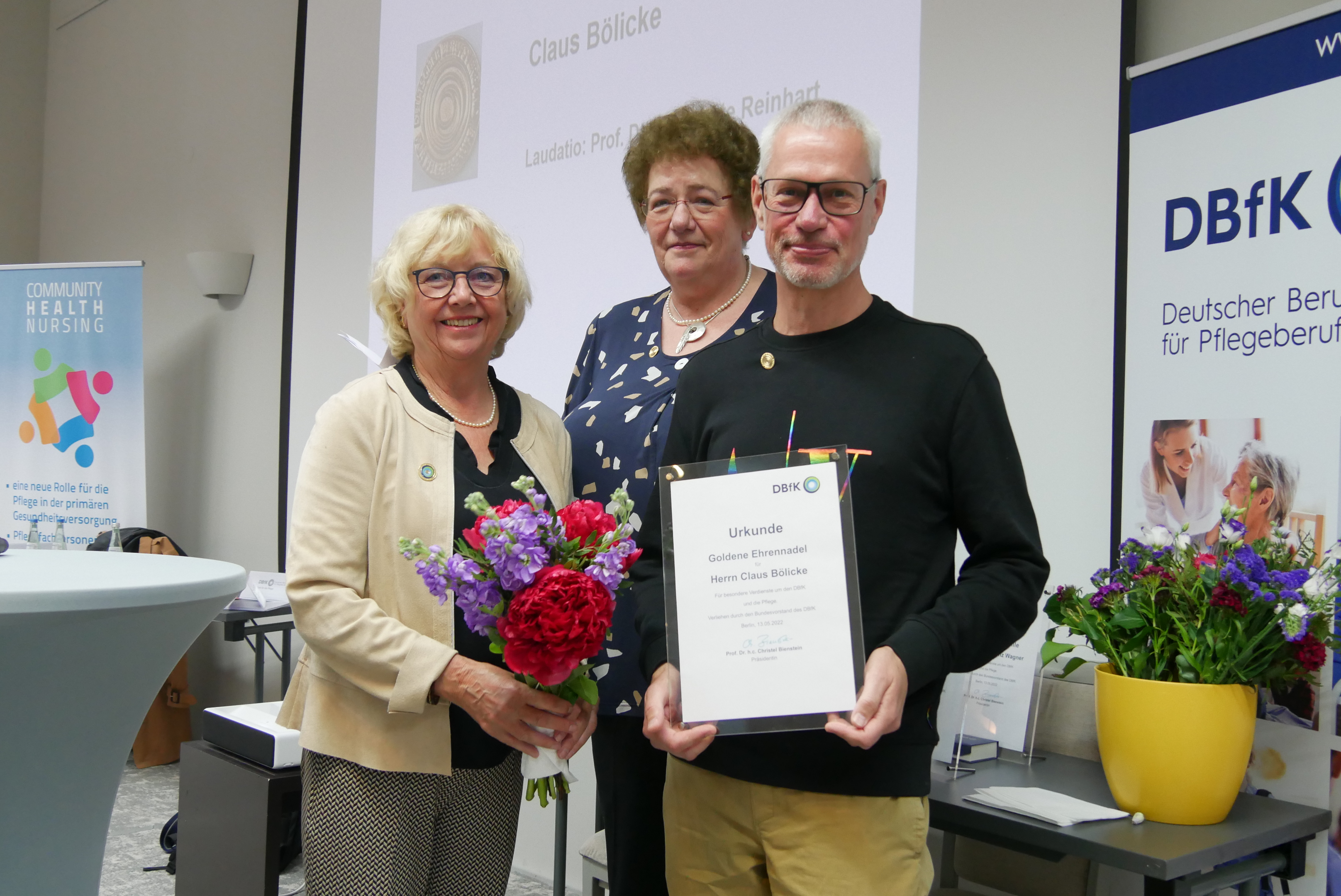 Prof. Dr. Christel Bienstein, Präsidentin des DBfK, Prof. Dr. Margarete Reinhart und Claus Bölicke mit einer Urkunde in der Hand. Das Foto ist von Ivonne Köhler-Roth.
