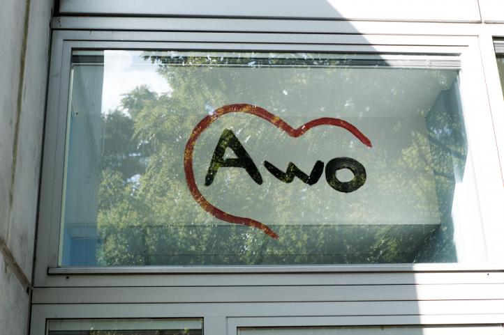 Auf eine Glastür ist das AWO Logo gemalt