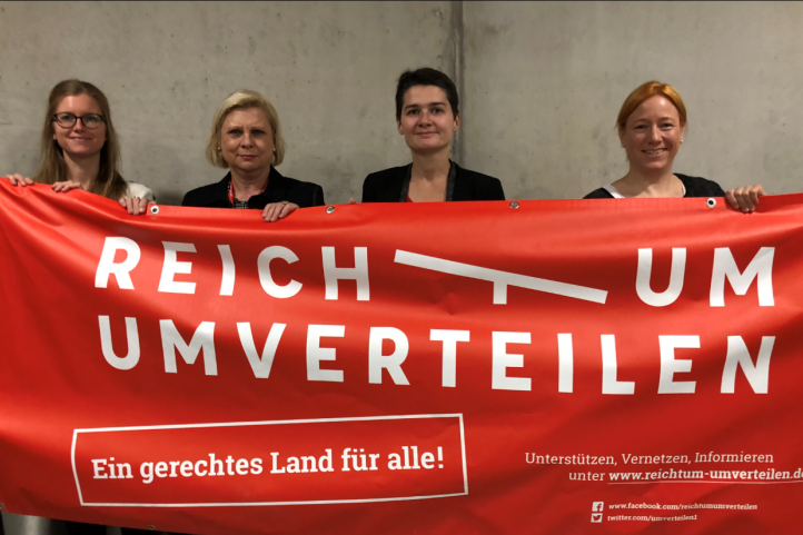 Bündnis Umverteilen bei der Briefübergabe beim SPD Parteitag hält ein Banner der Aktion 
