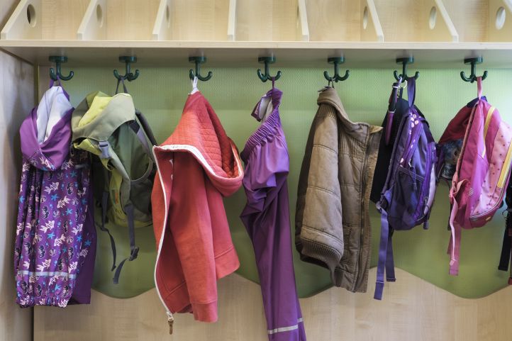 Jacken hängen an einer Kita-Garderobe