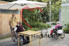 Zwei alte Menschen Seniorin und Senior im Rollstuhl sitzen auf der Terrasse