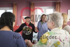 Mehrere alte Menschen Seniorinnen und Senioren tanzen im Kreis