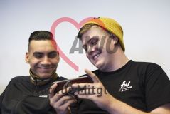 Zwei Jugendliche junge Männer in einem Workshop schauen auf ein Handy Smartphone und lachen