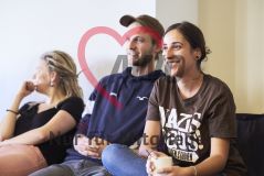 Mehrere Jugendliche zwei junge Frauen und ein junger Mann nehmen an einem Workshop Seminar teil und lächeln